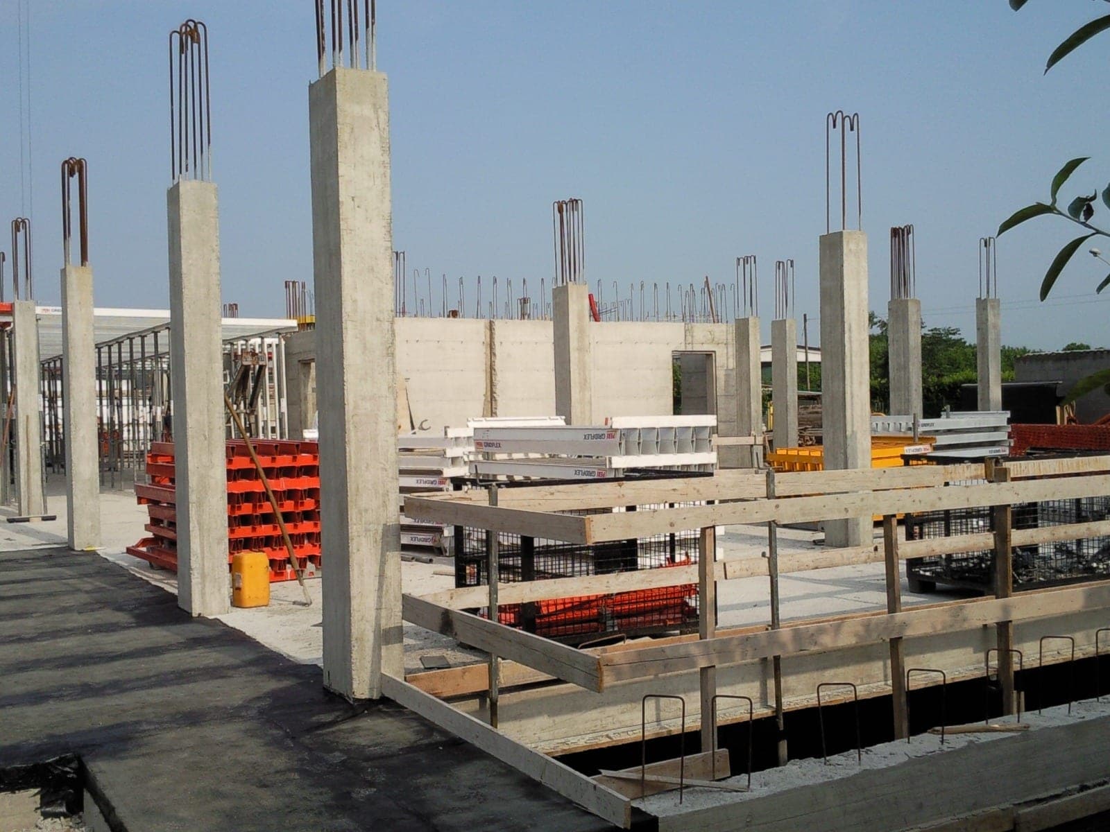 Cantiere con pilastri in cemento armato, ferri di ripresa e casseri per il getto
